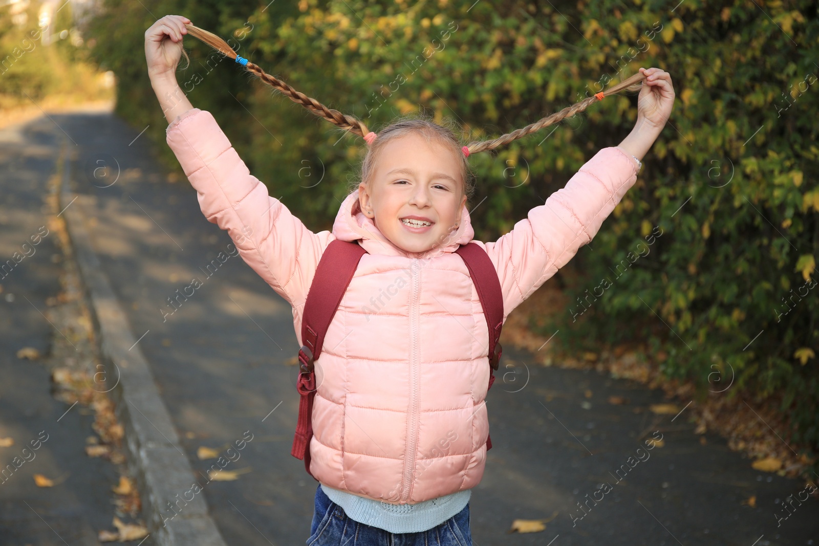 Photo of Cute little girl with backpack on city street