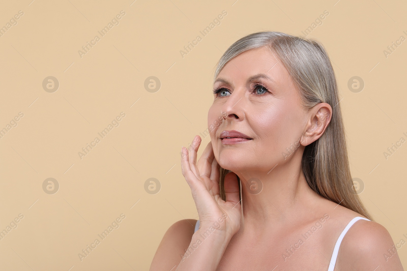 Photo of Portrait of beautiful senior woman on beige background. Space for text