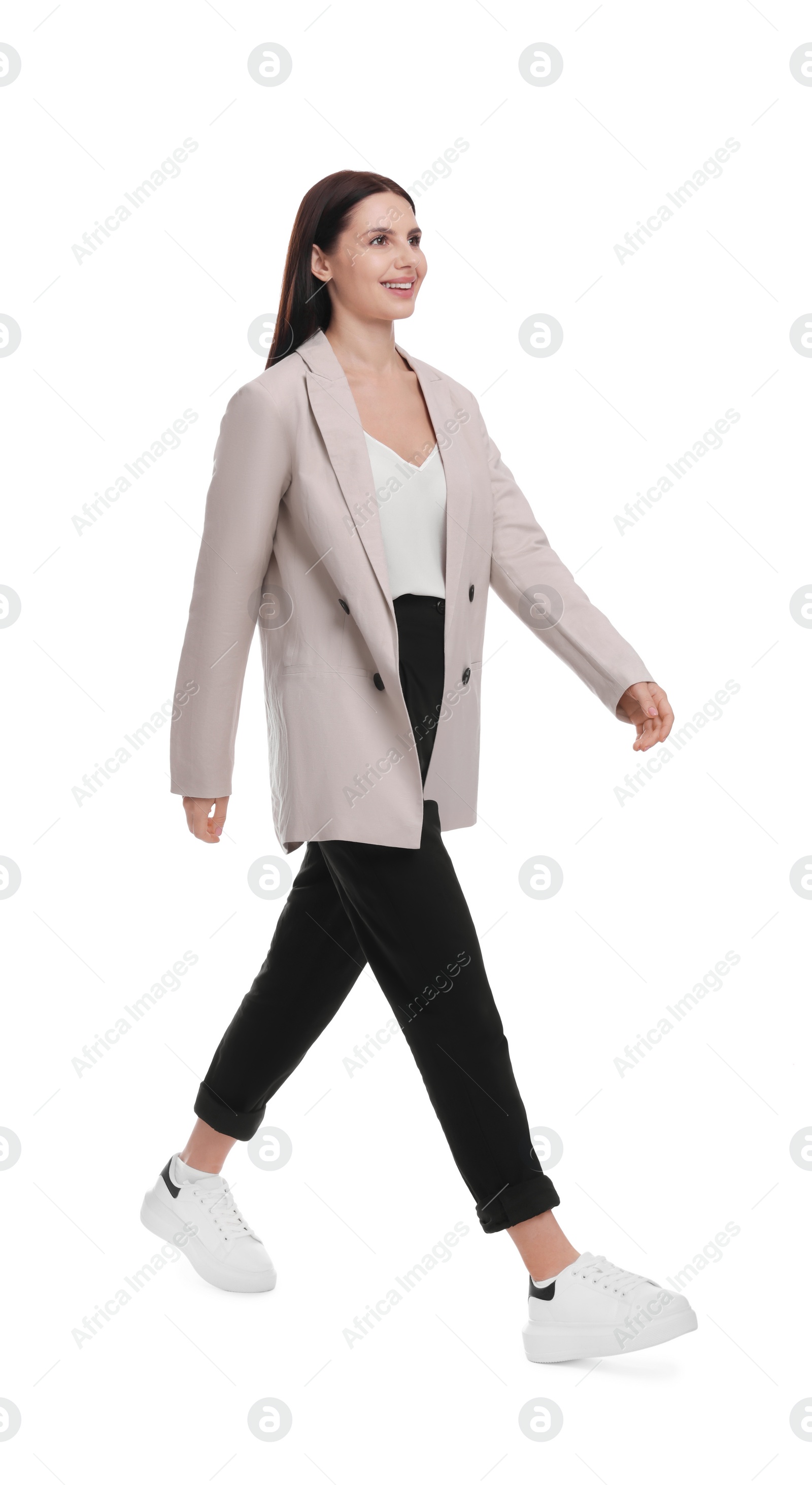 Photo of Beautiful businesswoman in suit with laptop walking on white background
