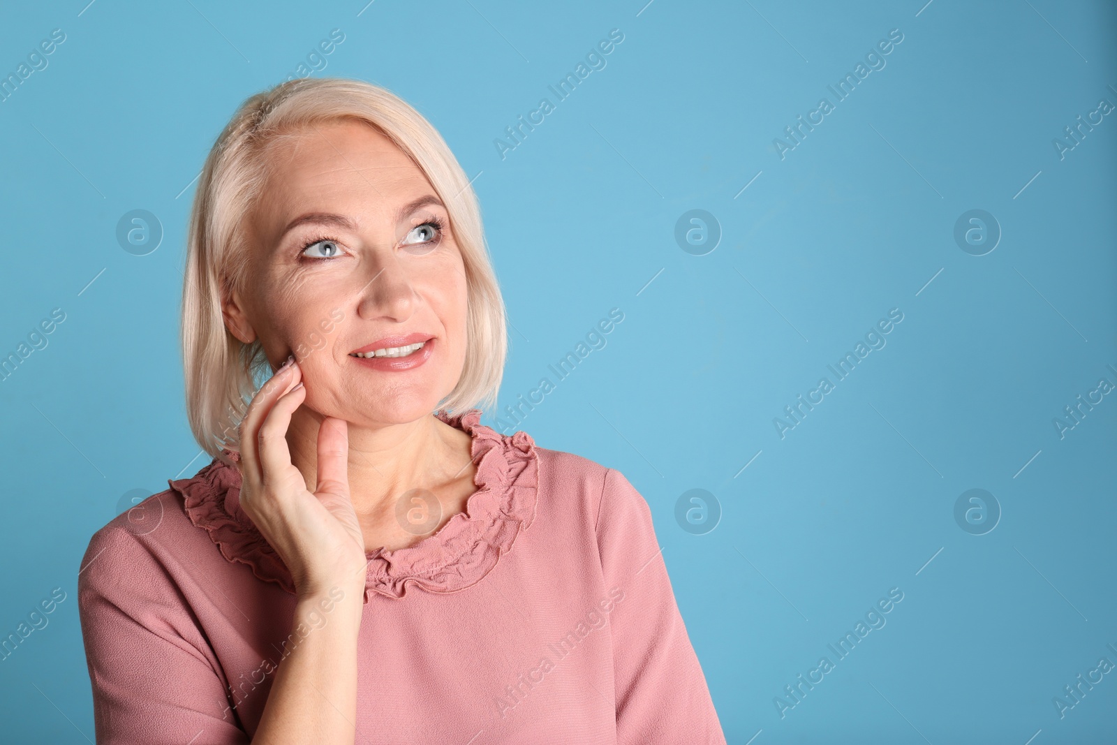 Photo of Portrait of charming mature woman with healthy beautiful face skin and natural makeup on blue background, space for text