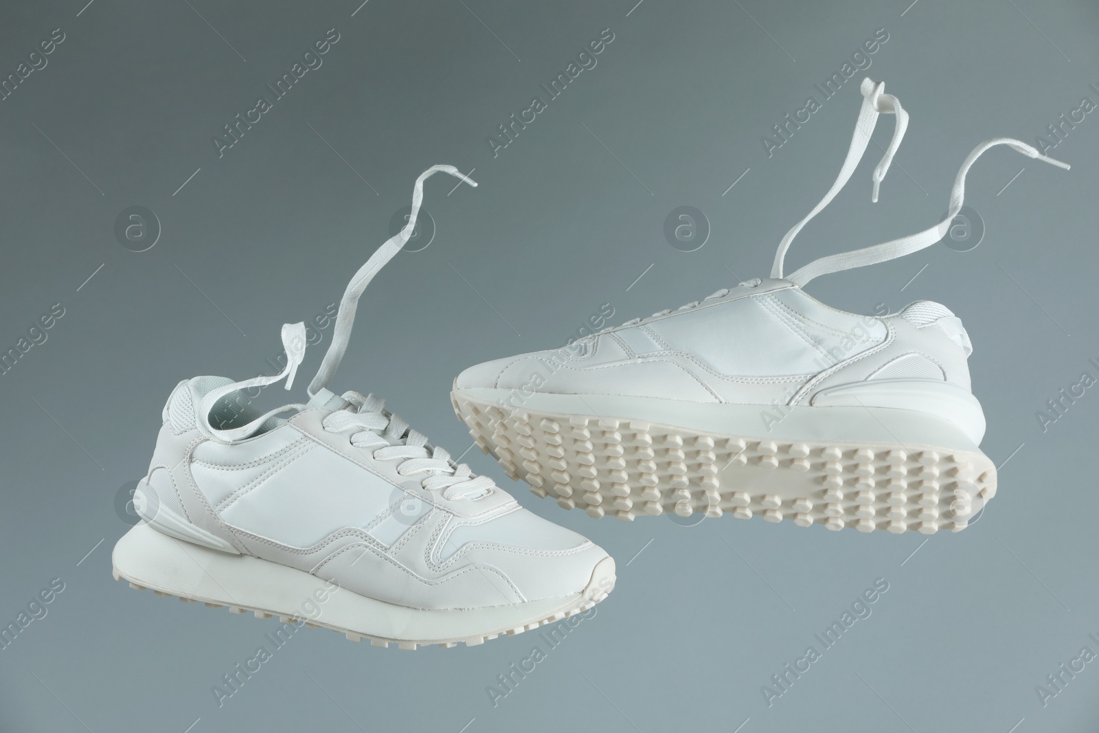 Photo of Pair of stylish white sneakers on light grey background