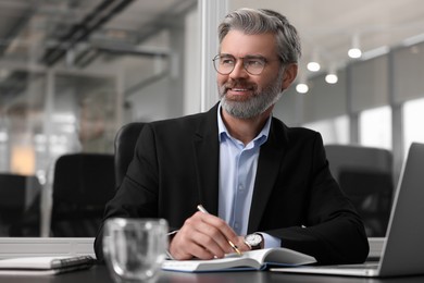 Smiling man at table in office. Lawyer, businessman, accountant or manager