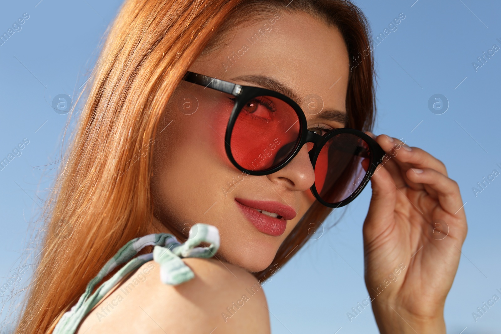 Photo of Beautiful woman in sunglasses against blue sky