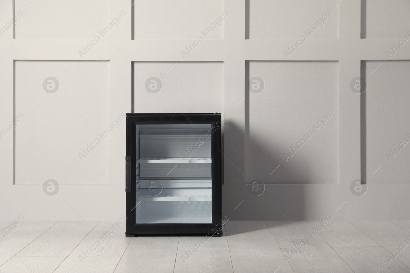 Photo of Empty mini bar with glass door near beige wall indoors. Space for text