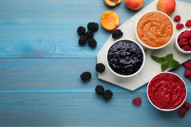 Different puree in bowls and fresh fruits on light blue wooden table, flat lay. Space for text