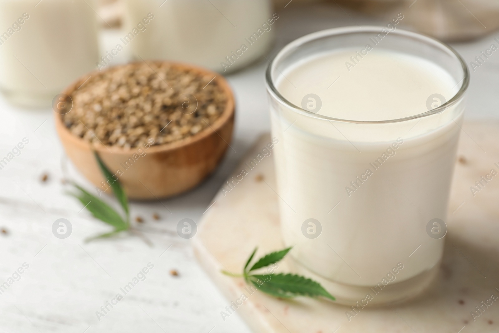 Photo of Composition with glass of hemp milk on white table, closeup. Space for text