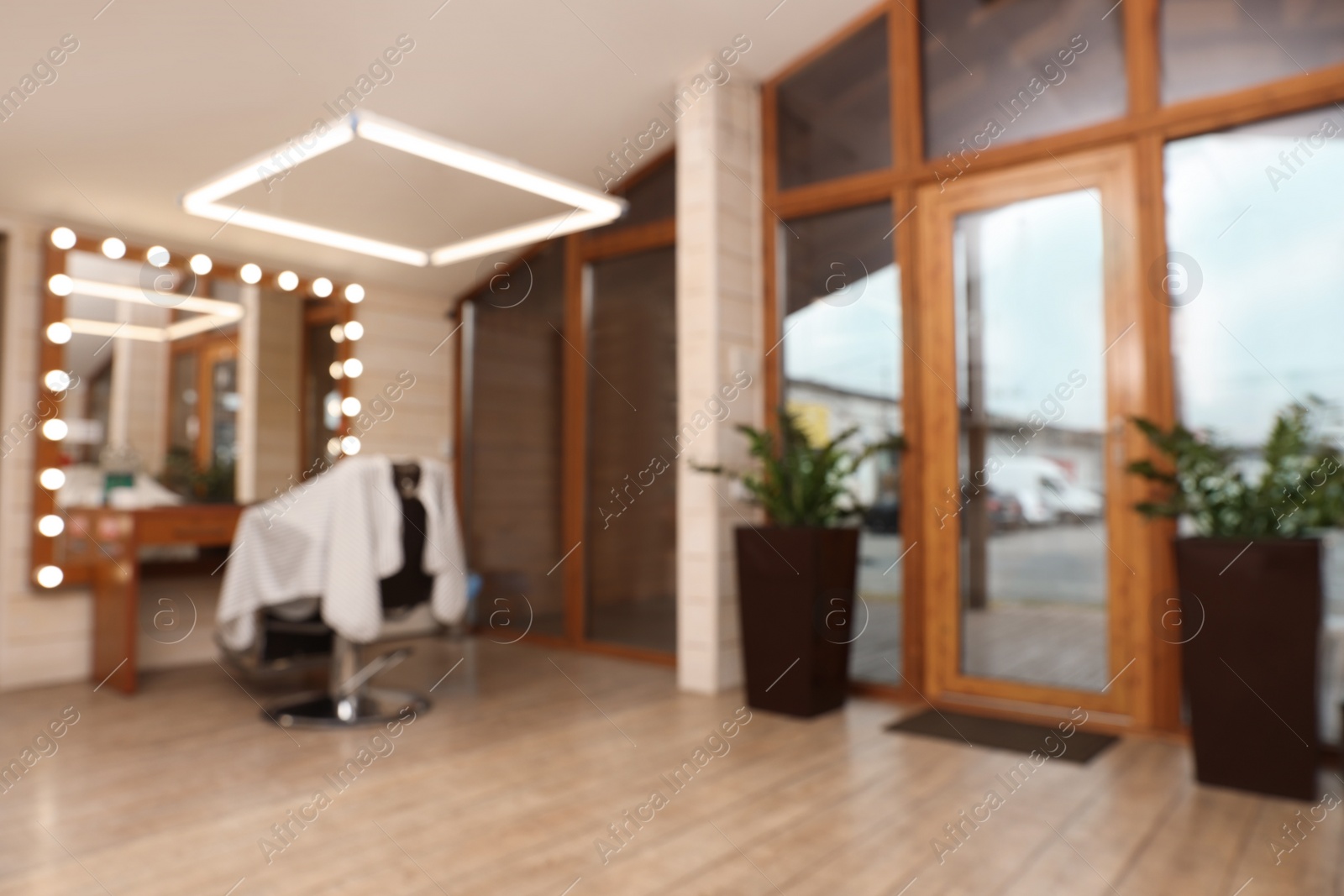 Photo of Blurred view of hairdressing salon with large mirror and chair