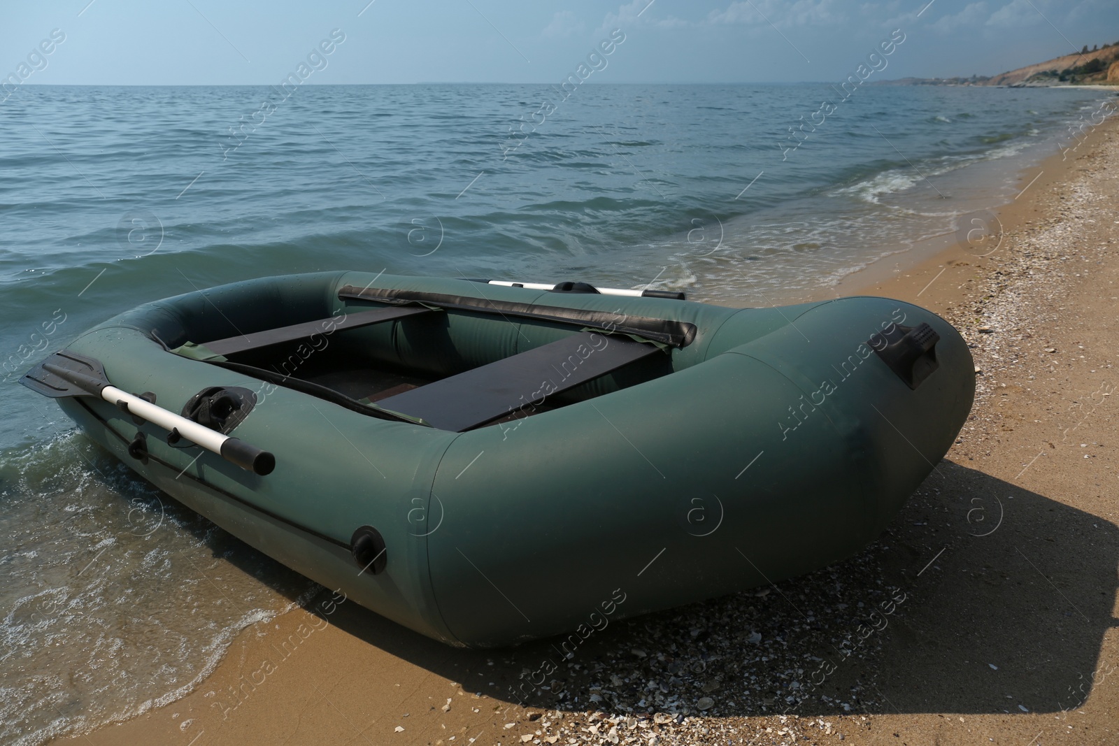 Photo of Inflatable rubber fishing boat on sandy beach near sea