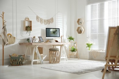 Photo of Stylish home office interior with comfortable workplace and easel