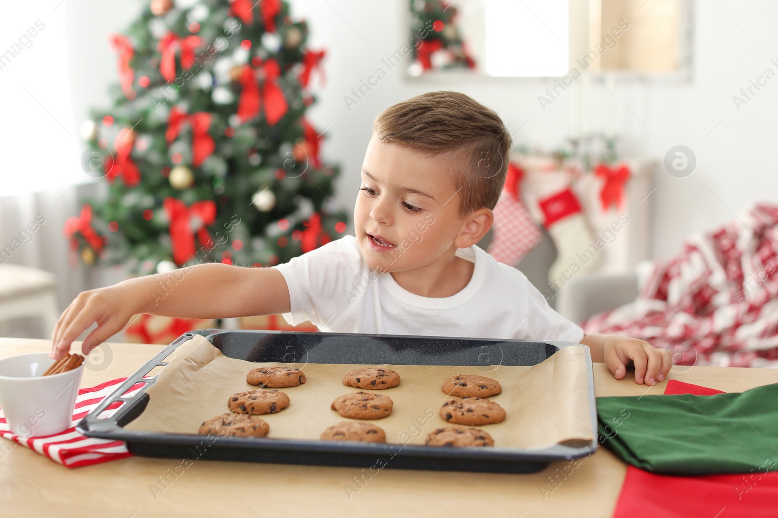 Photo of Cute child with Christmas cookies at home