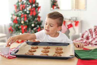 Photo of Cute child with Christmas cookies at home
