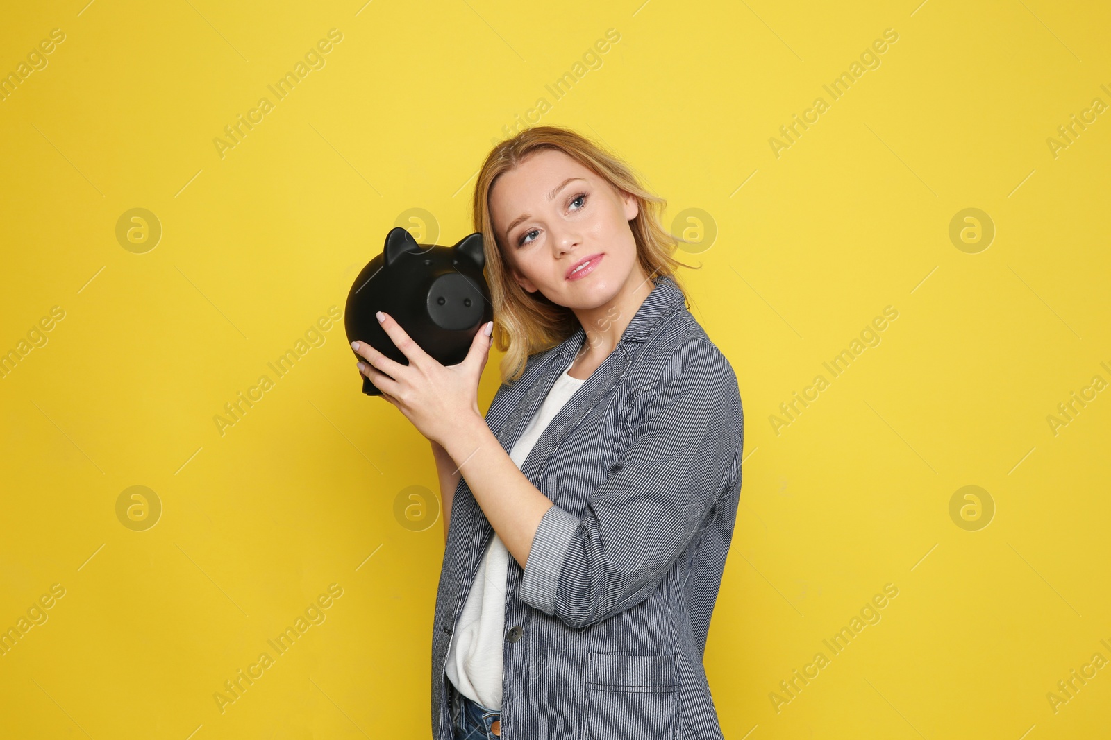 Photo of Beautiful young woman with piggy bank on color background
