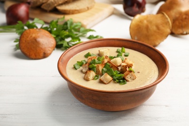 Photo of Bowl of fresh homemade mushroom soup on wooden table