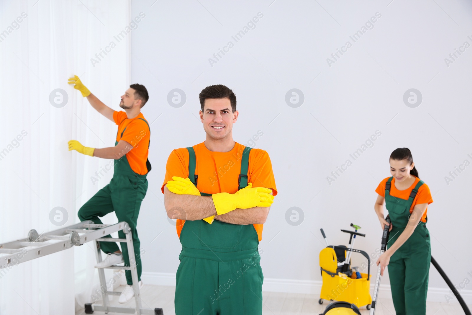 Photo of Team of professional janitors cleaning room after renovation