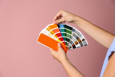 Photo of Female interior designer with palette samples on color background, closeup. Space for text