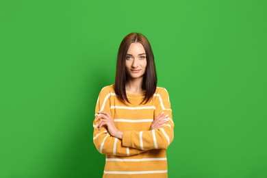 Image of Chroma key compositing. Beautiful young woman against green screen