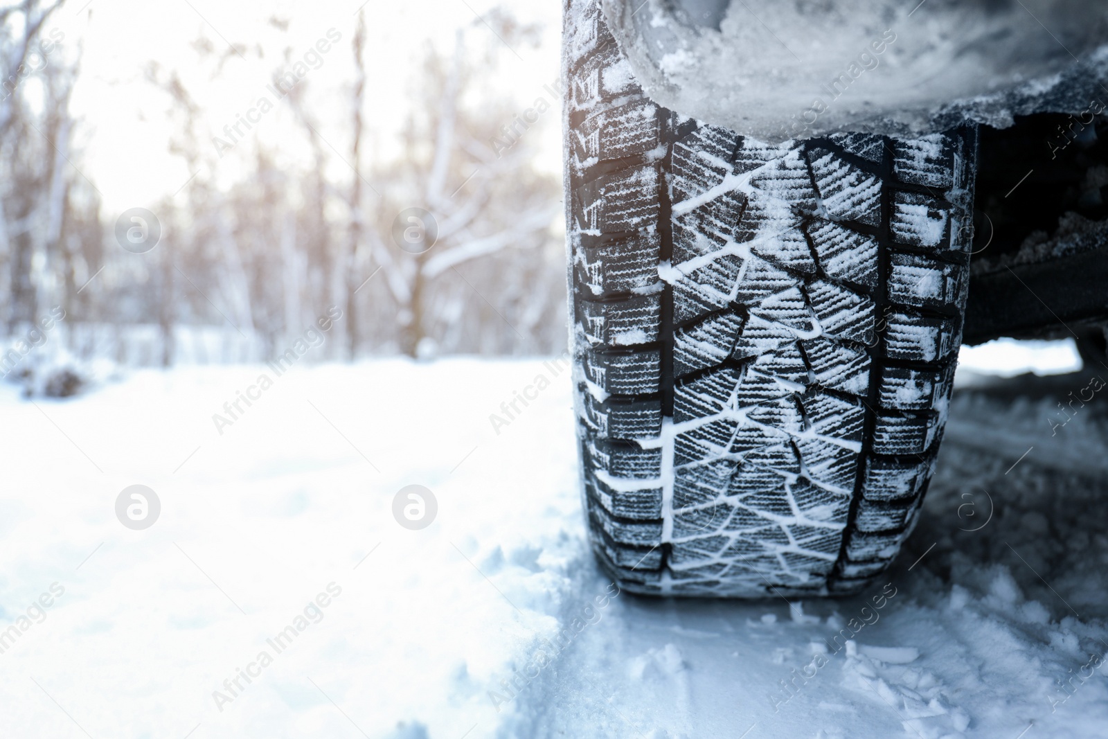 Photo of Snowy country road with car on winter day, closeup. Space for text