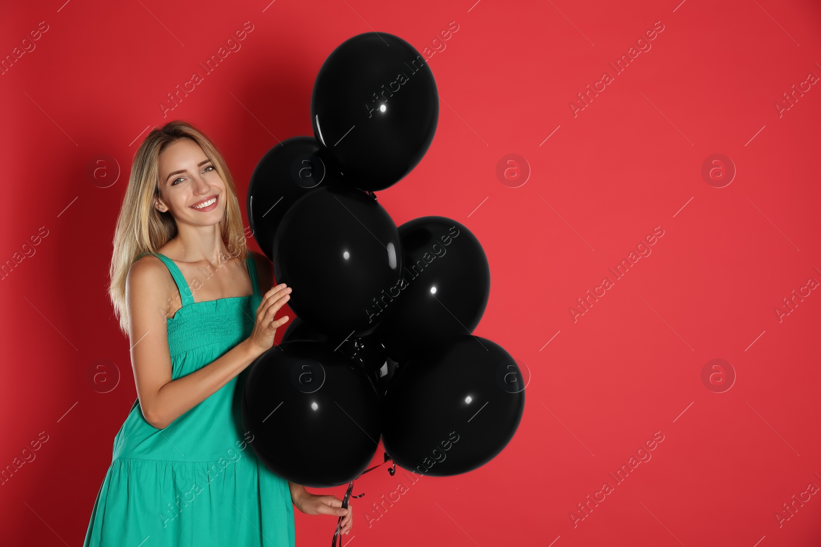 Photo of Happy young woman with balloons on red background, space for text. Black Friday Sale