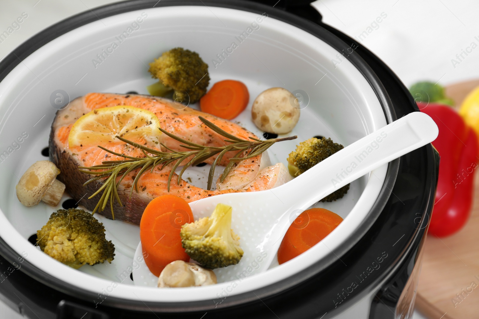 Photo of Salmon steak with garnish in multi cooker, closeup