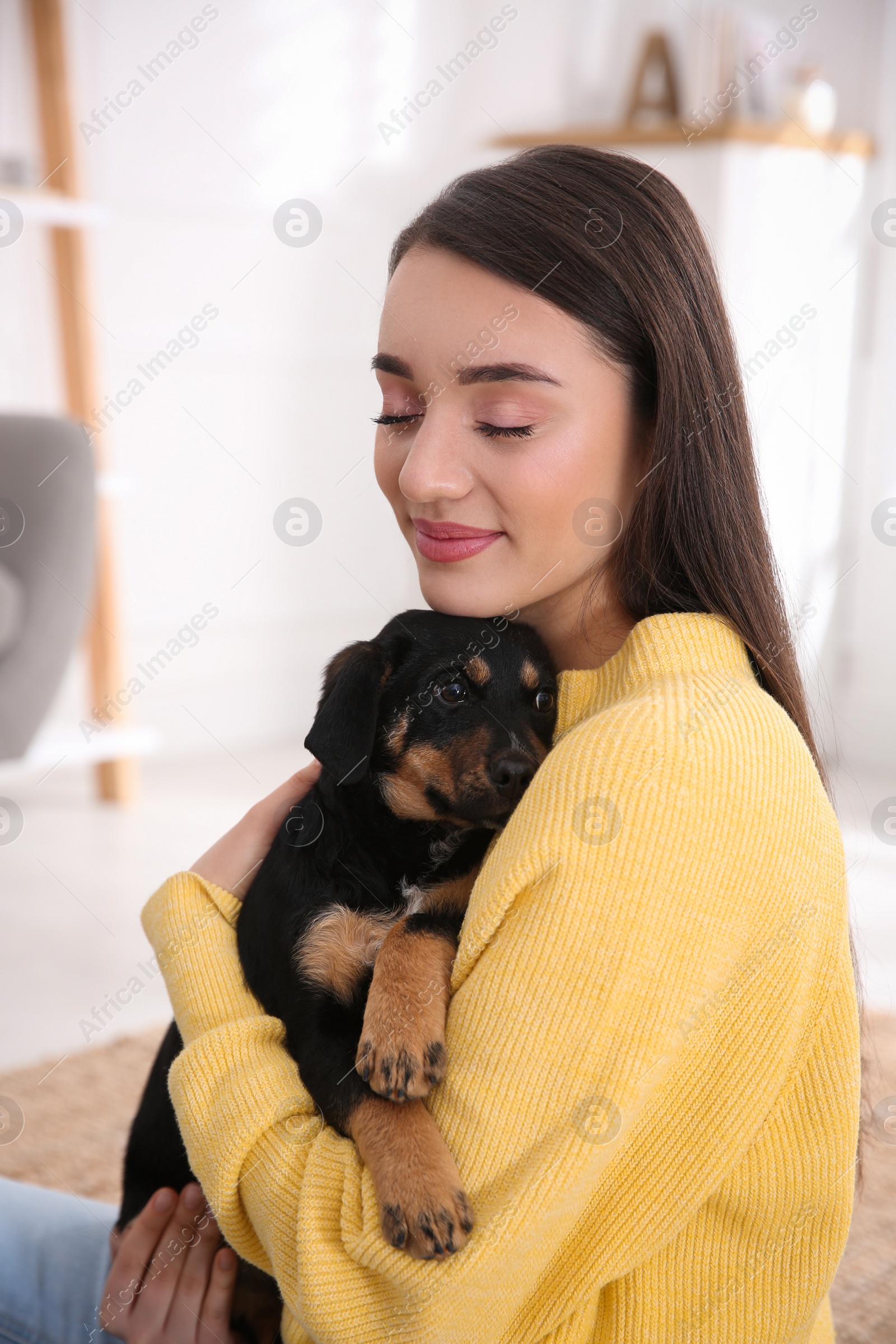 Photo of Woman with cute puppy indoors. Lovely pet