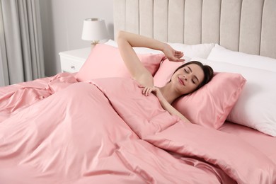 Photo of Young woman awaking in comfortable bed with silky linens