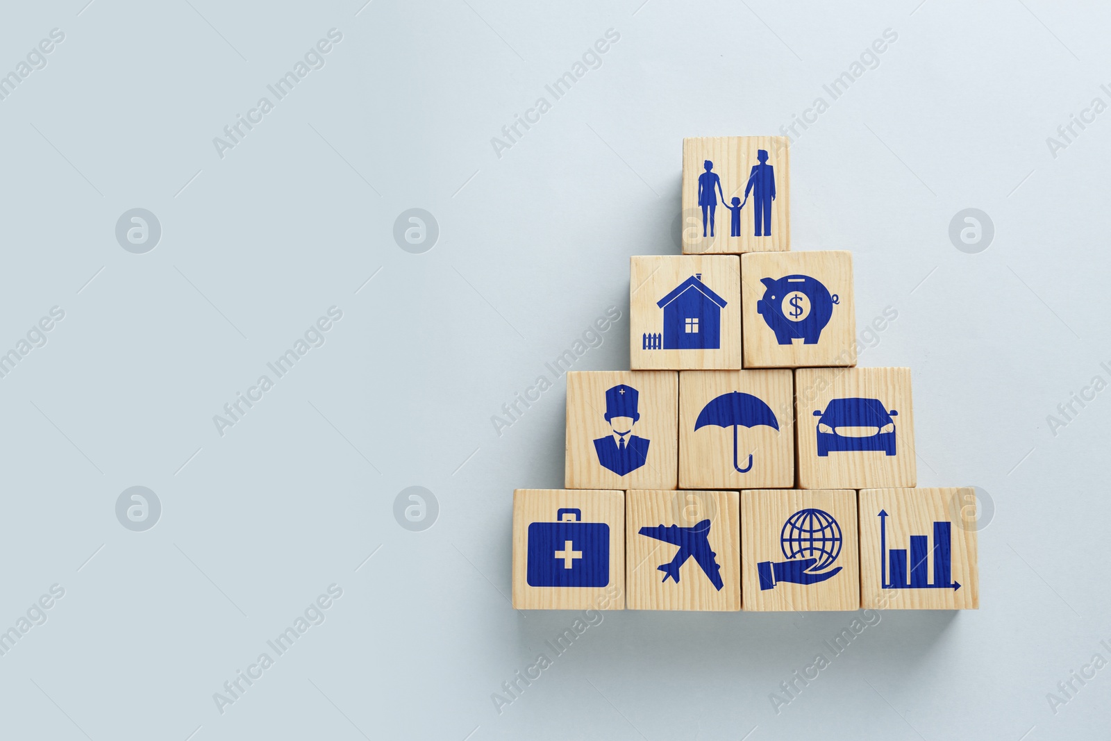 Image of Wooden cubes with different icons on light background, flat lay. Insurance concept