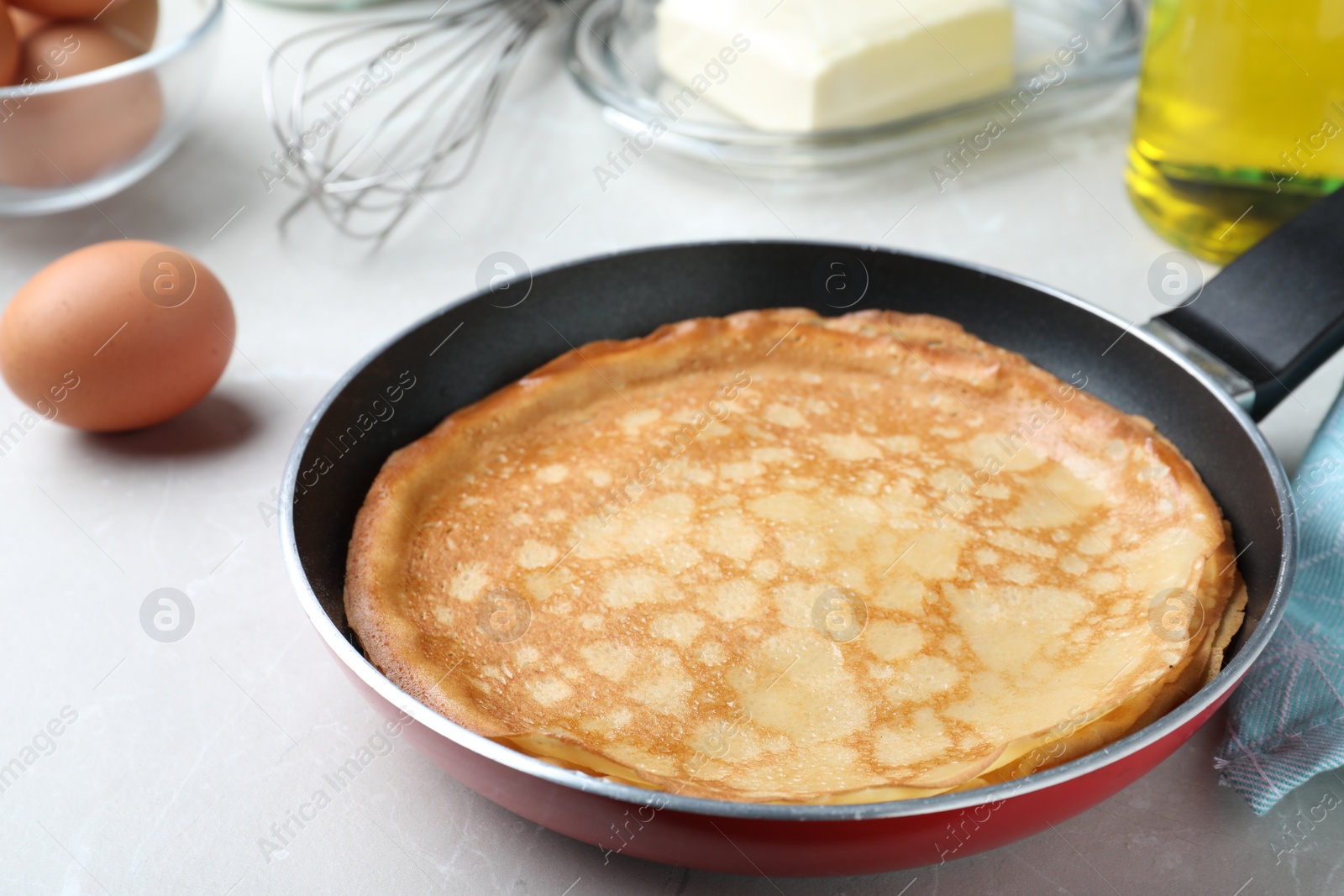 Photo of Delicious thin pancakes on grey marble table, closeup