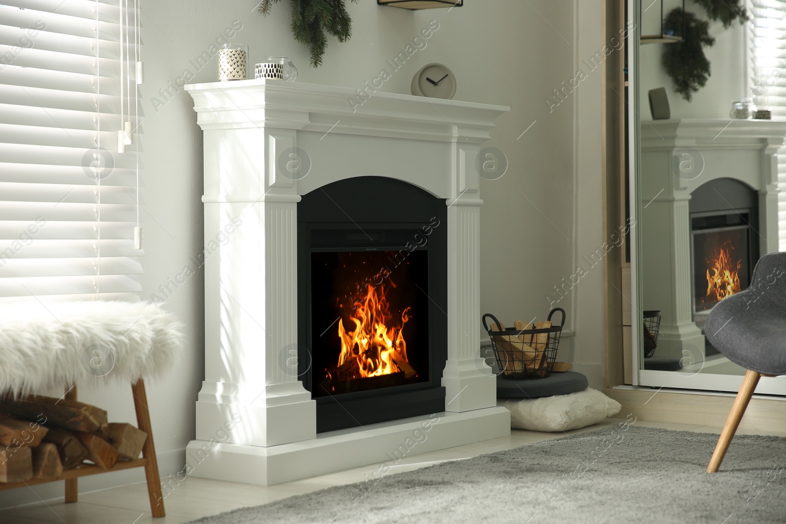 Photo of Bright living room interior with artificial fireplace and firewood in basket