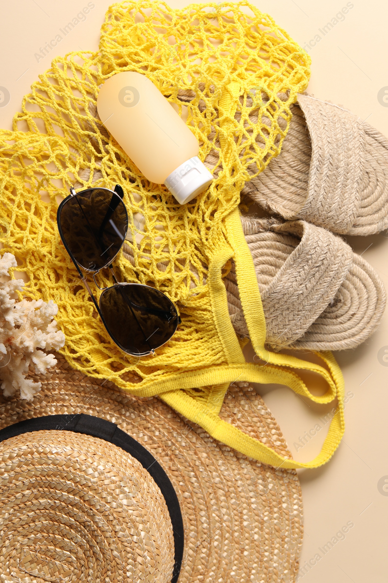 Photo of String bag and different beach accessories on beige background, top view