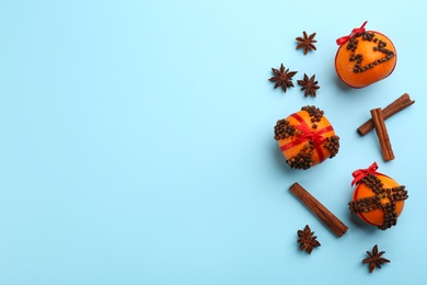 Flat lay composition with pomander balls made of fresh tangerines on light blue background. Space for text