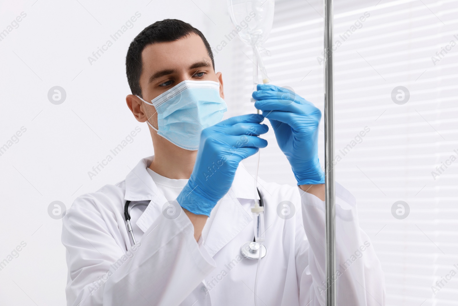 Photo of Doctor setting up IV drip in hospital