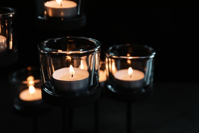 Photo of Burning candles on dark background. Funeral symbol