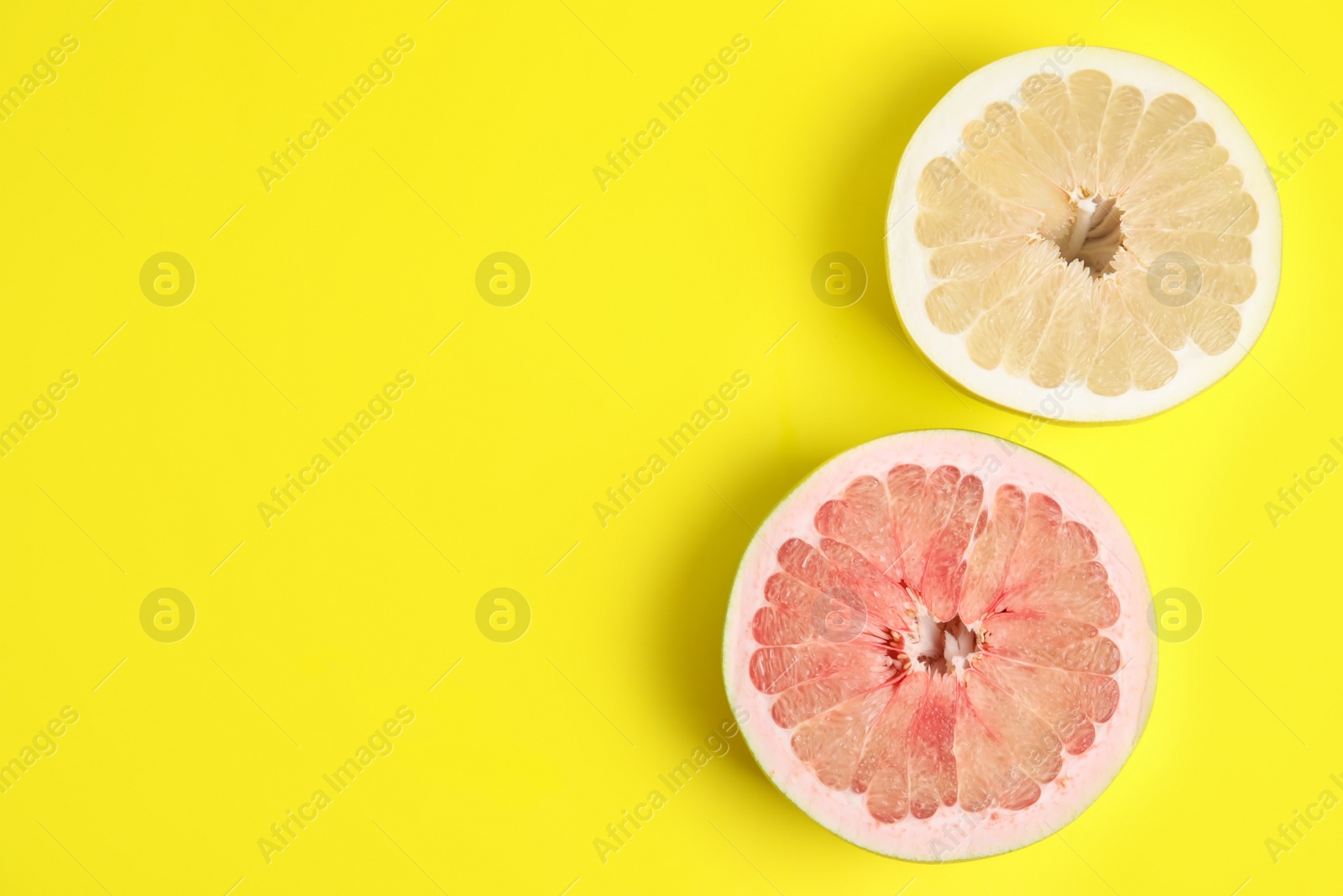 Photo of Fresh cut pomelo fruits on yellow background, flat lay. Space for text