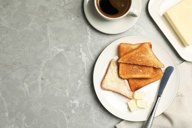 Tasty toasts with butter served on grey marble table, flat lay. Space for text