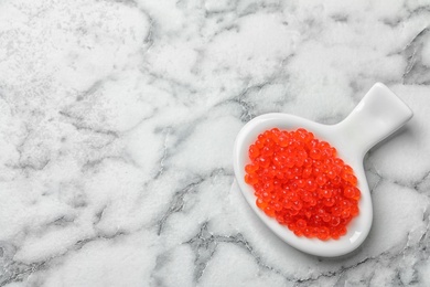 Photo of Dish with delicious red caviar on light background