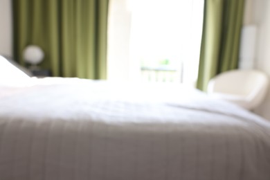 Photo of Blurred view of comfortable large bed in room