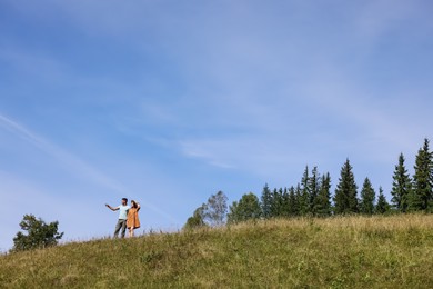 Photo of Couple spending time together on hill, space for text