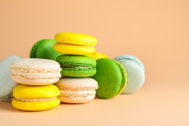 Photo of Delicious fresh colorful macarons on beige background