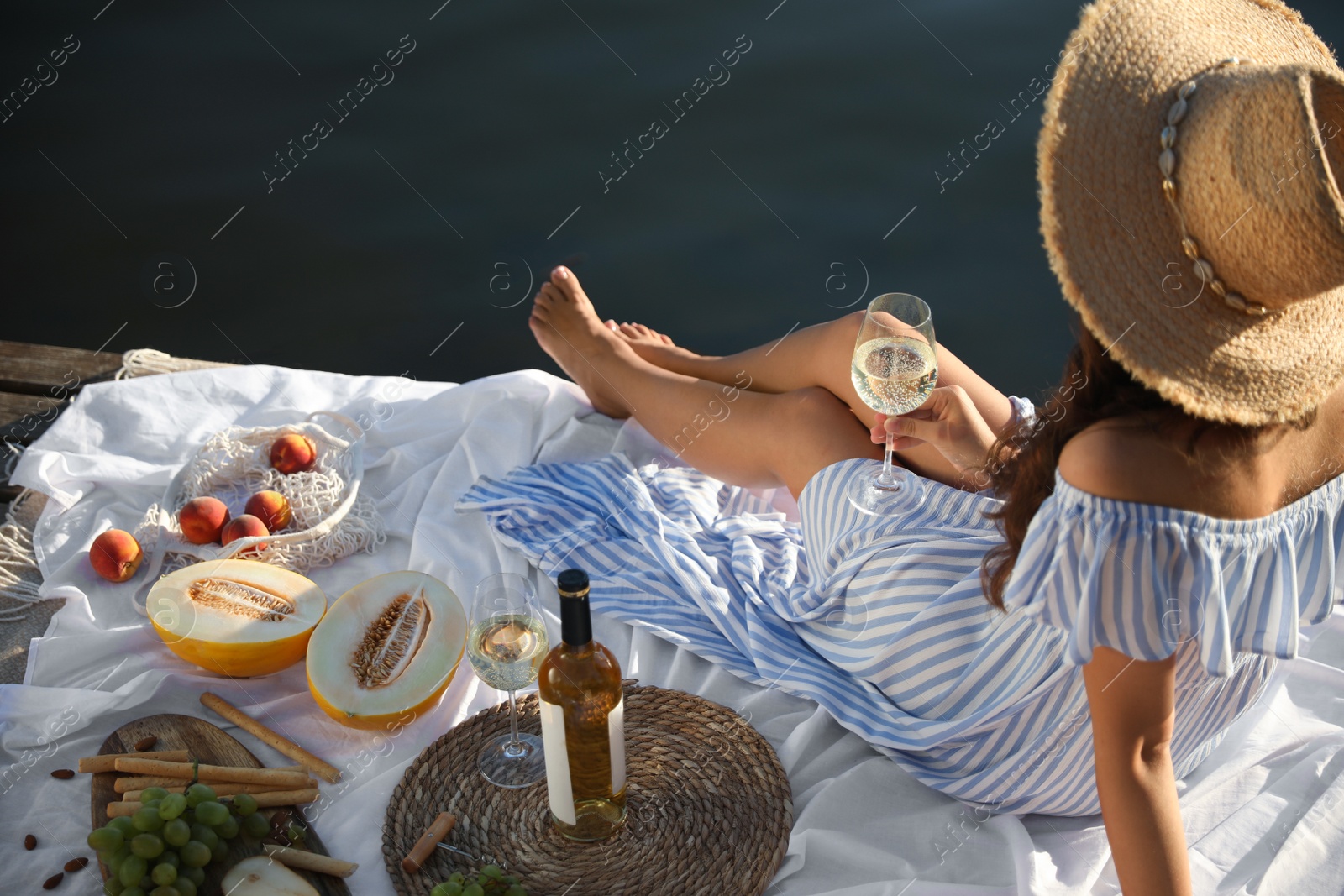 Photo of Young woman spending time on pier at picnic