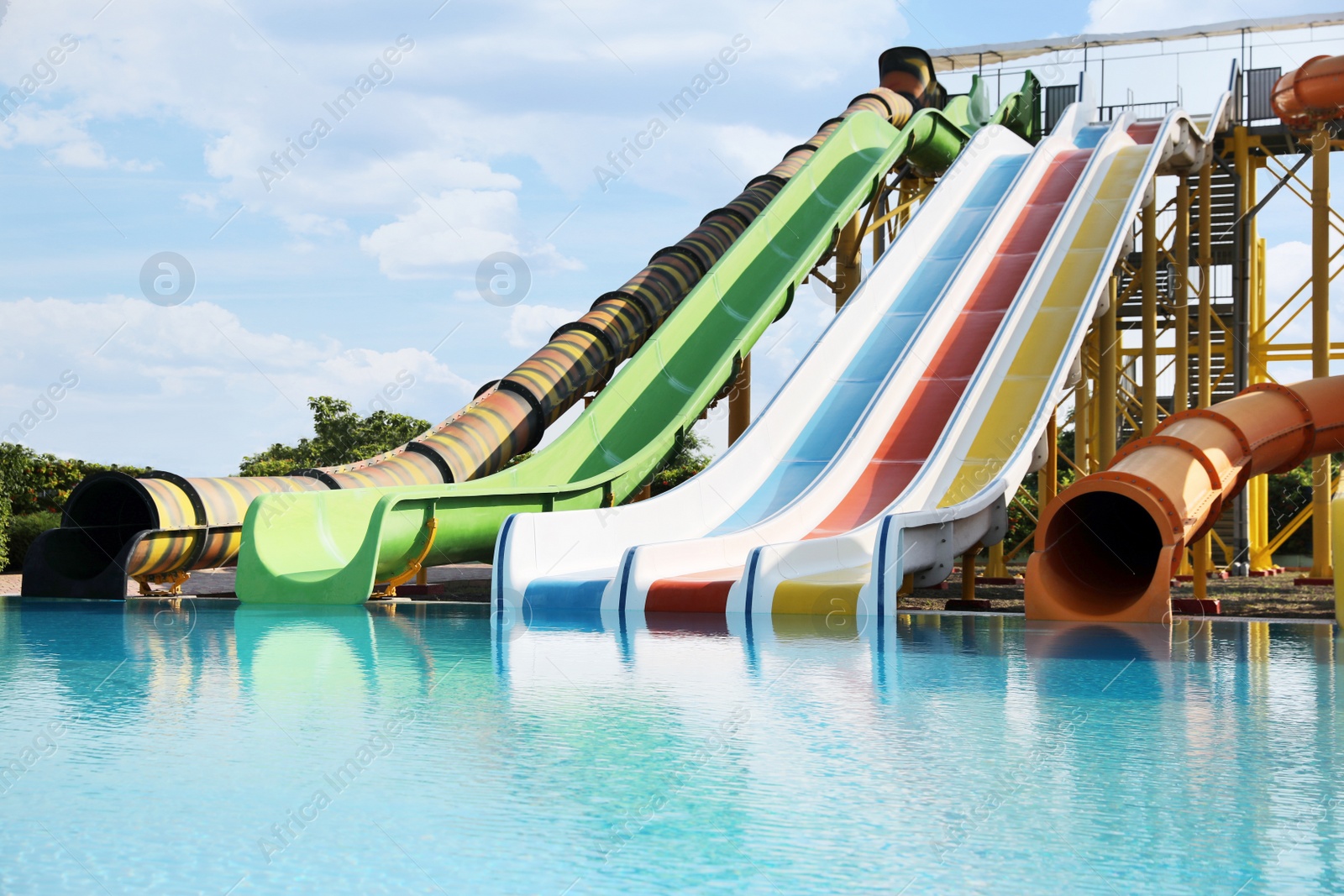 Photo of Beautiful view of water park with colorful slides and swimming pool on sunny day