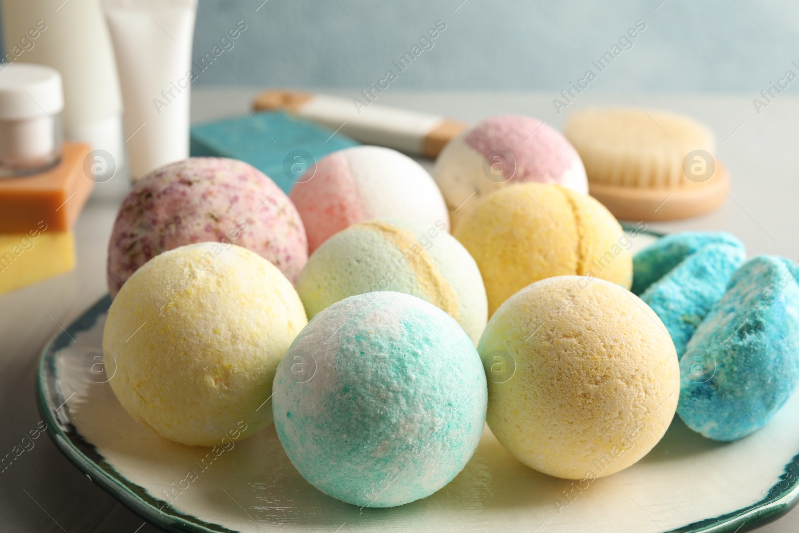 Photo of Plate with colorful bath bombs on table, closeup