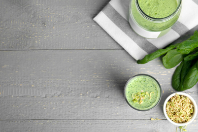 Photo of Flat lay composition with green buckwheat smoothie on light grey wooden table, space for text