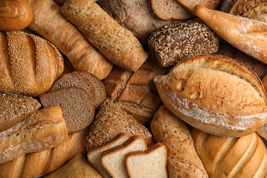 Photo of Different kinds of fresh bread as background, top view