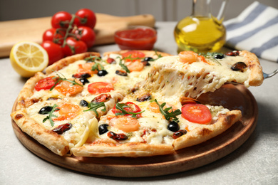 Photo of Taking slice of cheese pizza with seafood at grey table, closeup