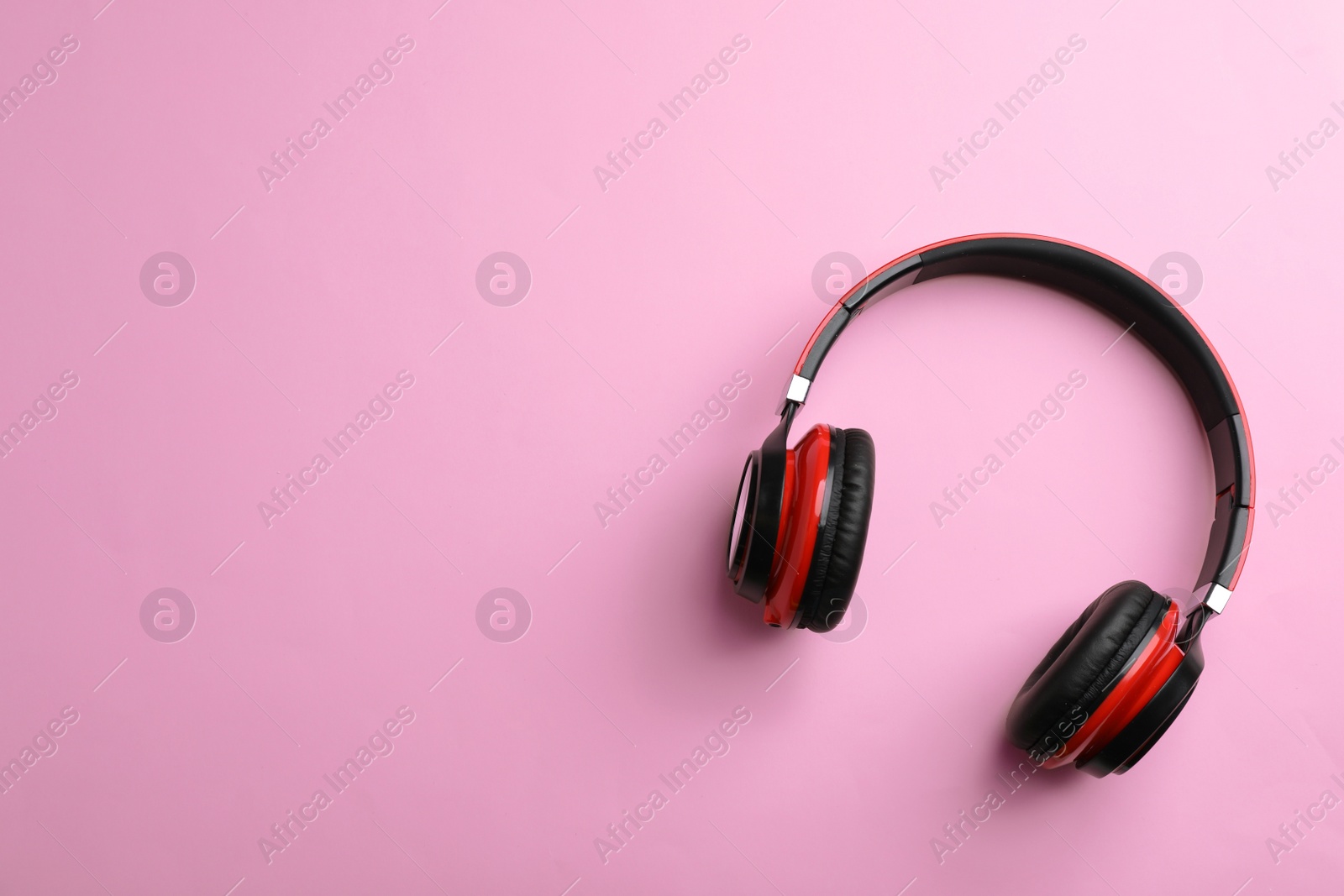 Photo of Wireless headphones on color background, top view. Space for text