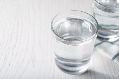 Glass of soda water on white wooden table. Space for text