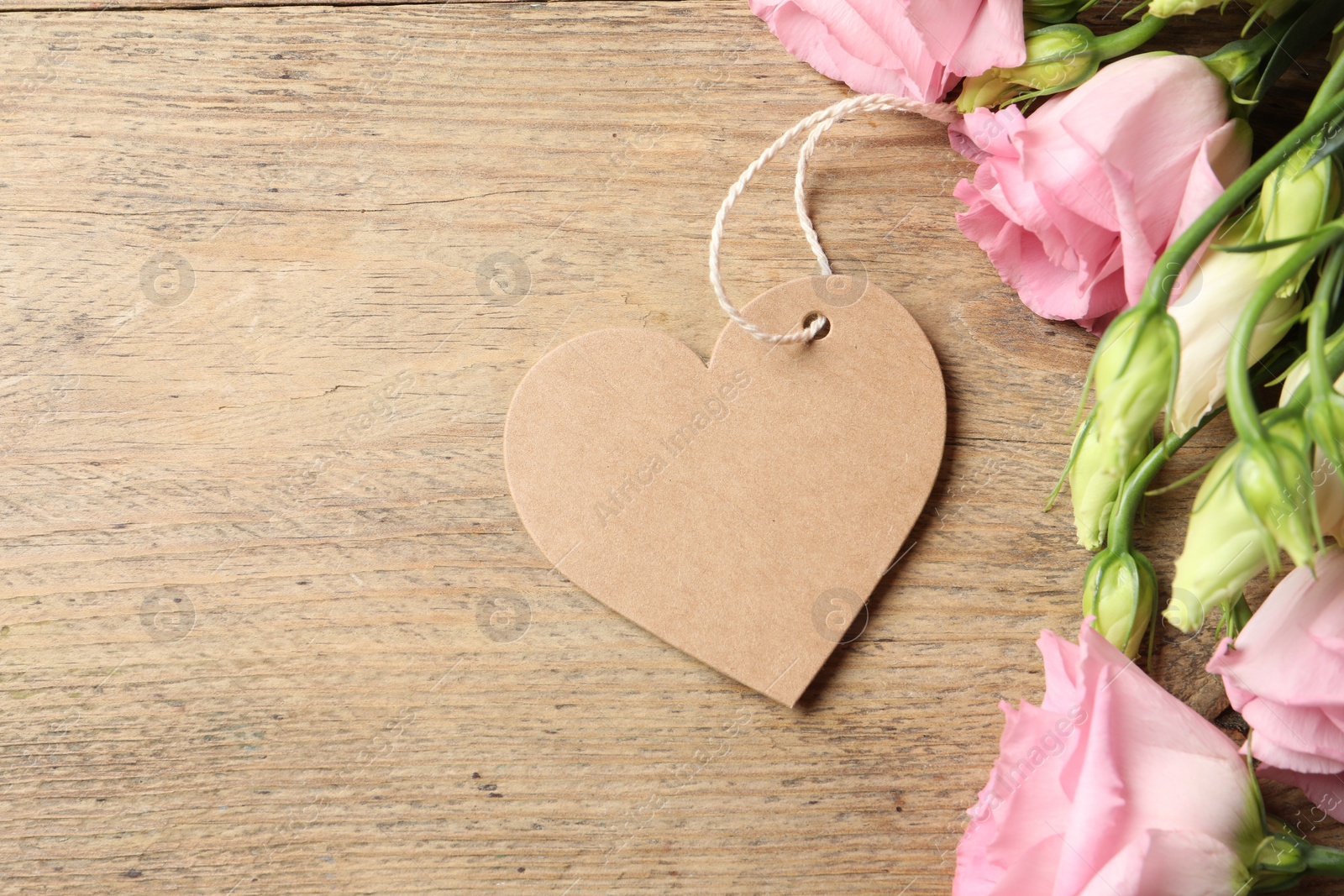 Photo of Happy Mother's Day. Beautiful flowers and blank heart shaped card on wooden table, space for text