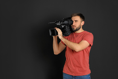 Photo of Operator with professional video camera on black background