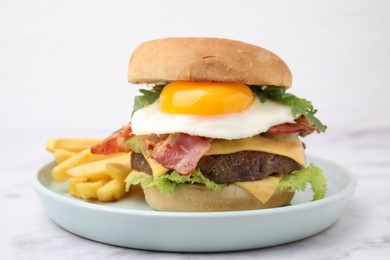 Photo of Delicious burger with fried egg and french fries served on white marble table, closeup