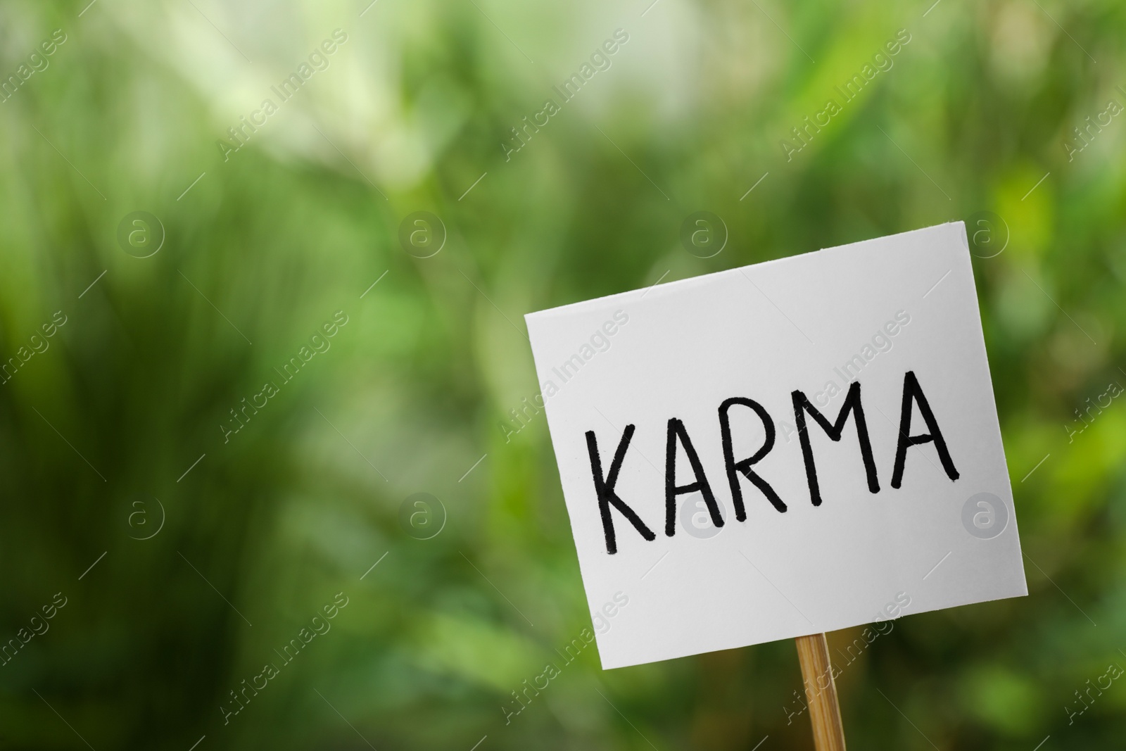 Photo of Sign with word Karma on blurred background, closeup. Space for text